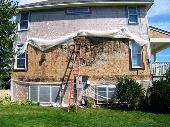Vista de la casa de madera de la pared después de desmontar el revestimiento. Minnesota, EE.UU..